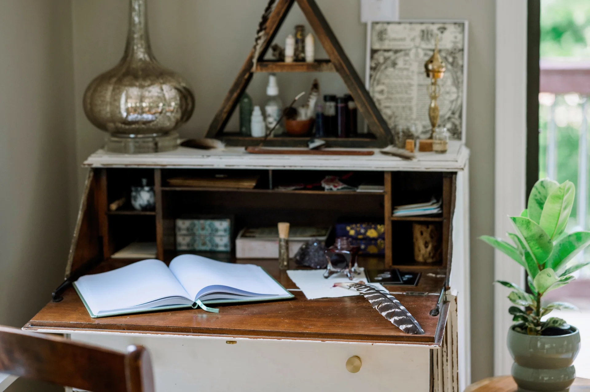 An inviting workspace featuring an open notebook, feather pen, and spiritual tools arranged on a vintage desk, reflecting a soulful and intentional atmosphere.