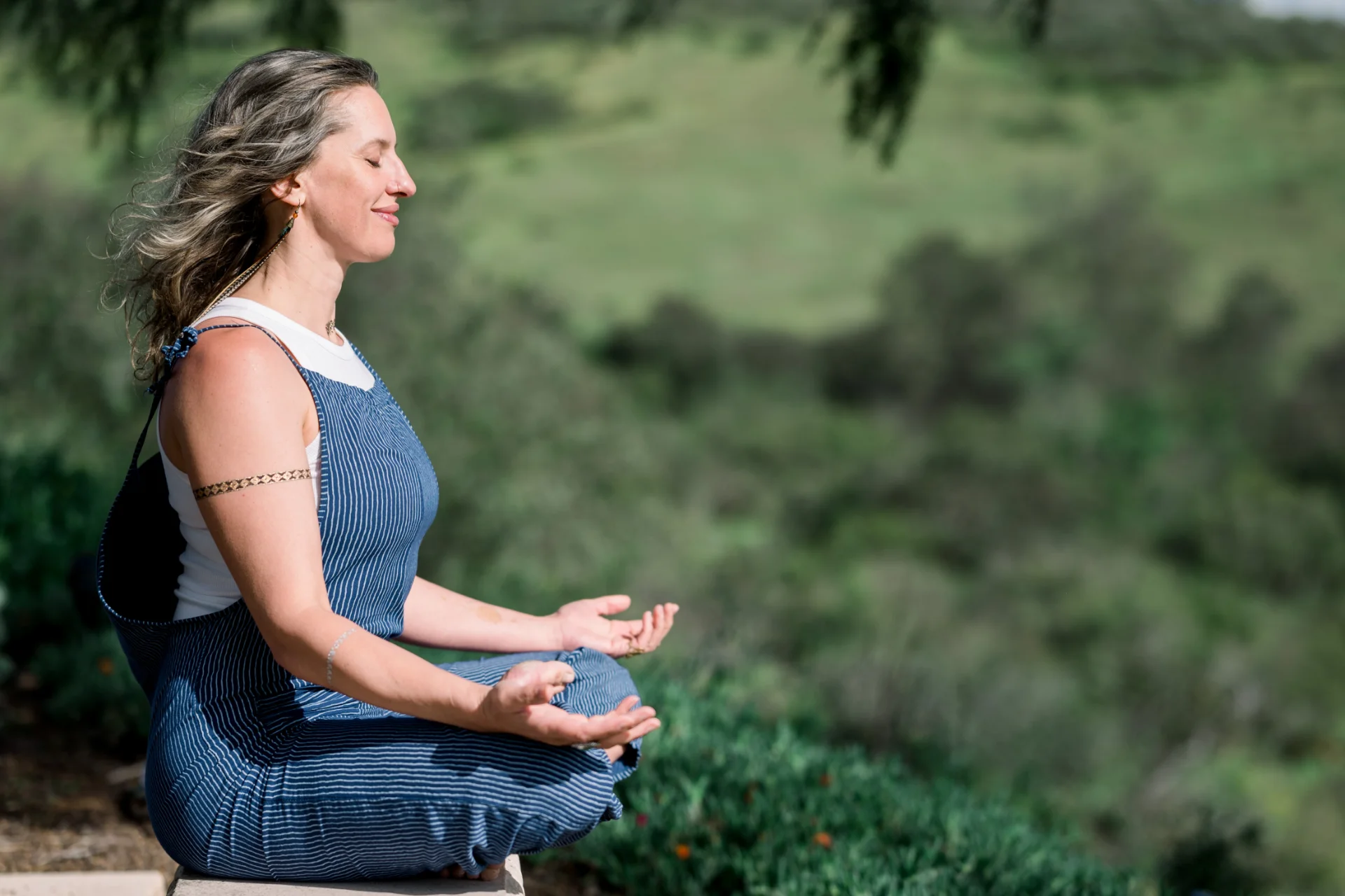 Woman meditating outdoors, symbolizing alignment and ease in growing a business through SEO strategies.